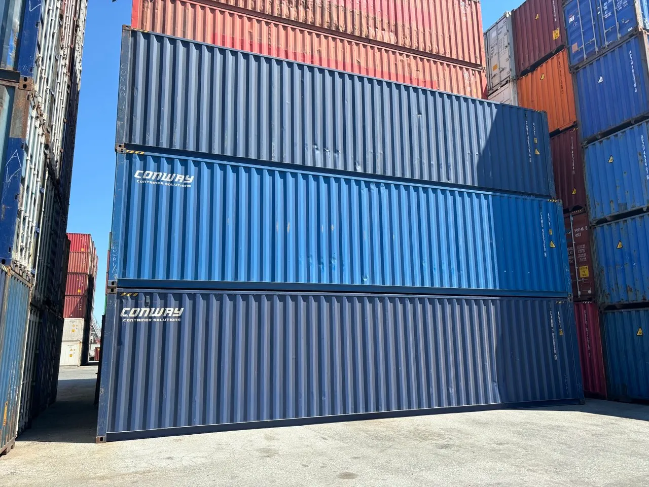 Stack of shipping containers in blue, grey and red