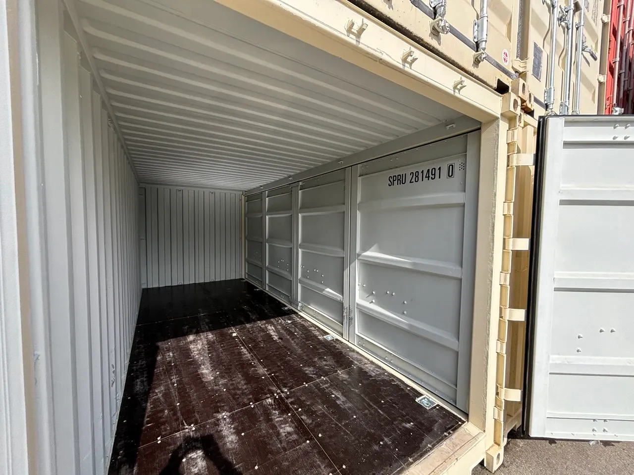 Inside a shipping container — open storage space with a wood floor